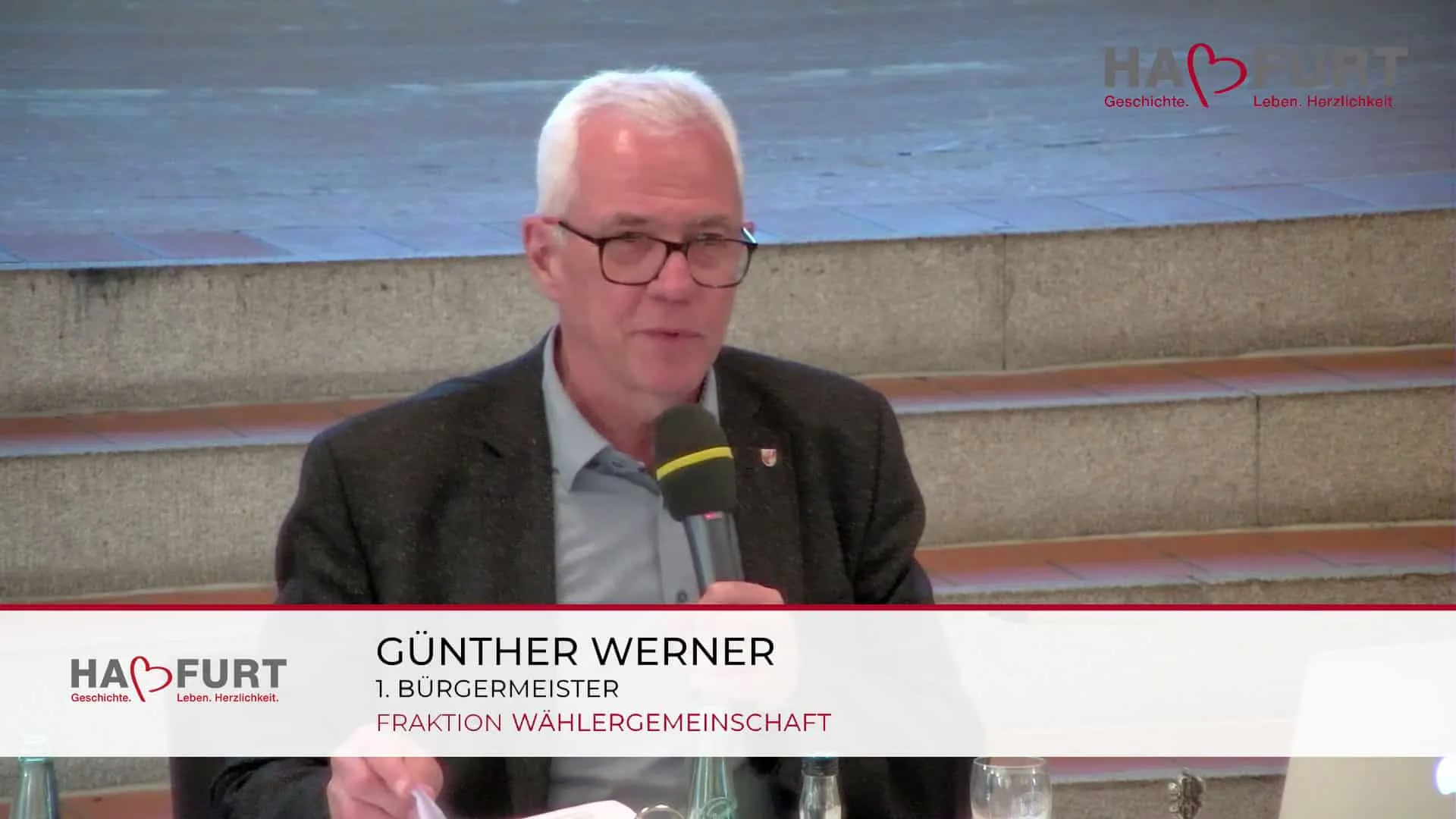 Live stream of the Haßfurt city council meeting with a lower third for Günther Werner, First Mayor